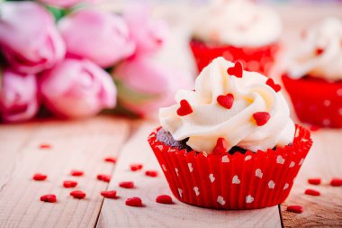 Sevgililer günü için vanilya krem ve kırmızı şeker kalpler ile çikolata cupcakes