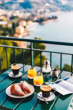 İtalya deniz manzaralı balkon lezzetli kahvaltı kahve, pasta ve portakal suyu ile servis.