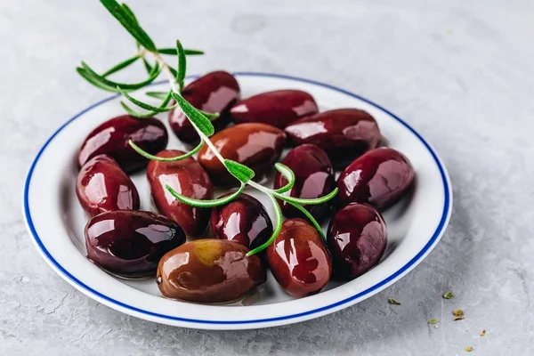 İtalyan zeytin zeytin yağı ve biberiye dalı bir plaka üzerinde
