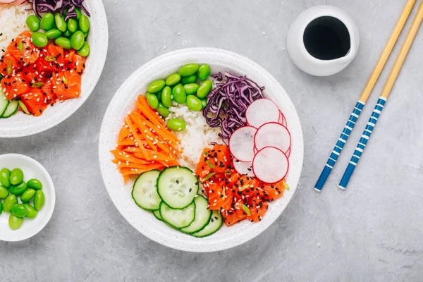 Boliche de salmão com arroz, rabanete, pepino, cenoura, edamame, repolho vermelho e sementes de gergelim . — Fotografia de Stock