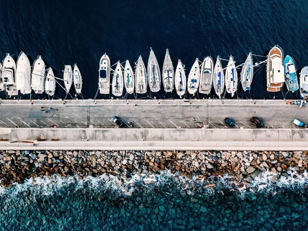 Вид с воздуха на пристань с лодками и яхтами в Италии. Голубой морской пейзаж с видом на белые яхты — стоковое фото