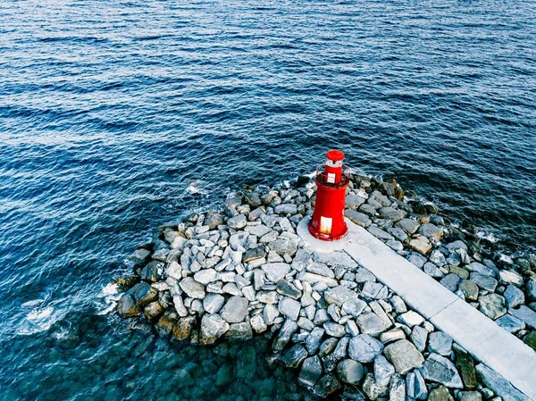 Veduta aerea del piccolo faro rosso nel mare blu — Foto Stock