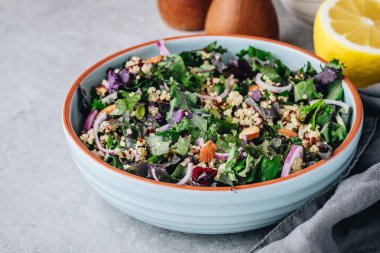 Sağlıklı kase kale ve kızılcık, kırmızı soğan ve badem ile quinoa salatası 