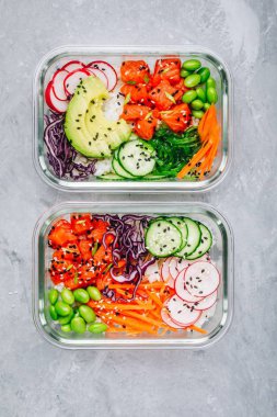 Somon, pirinç, turp, salatalık ve avokado ile poke yemek hazırlık kapları.