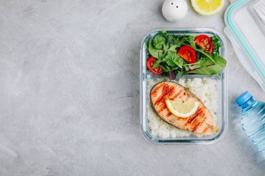 Somon ve pirinç ile Yemek hazırlık kapları, domates ile yeşil karışımı salata. Üst görünüm, kopyalama alanı