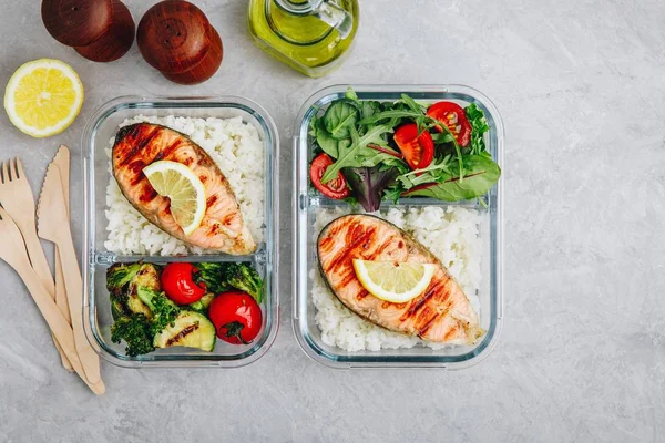 stock image Meal prep containers with salmon and rice, green salad and baked vegetables.