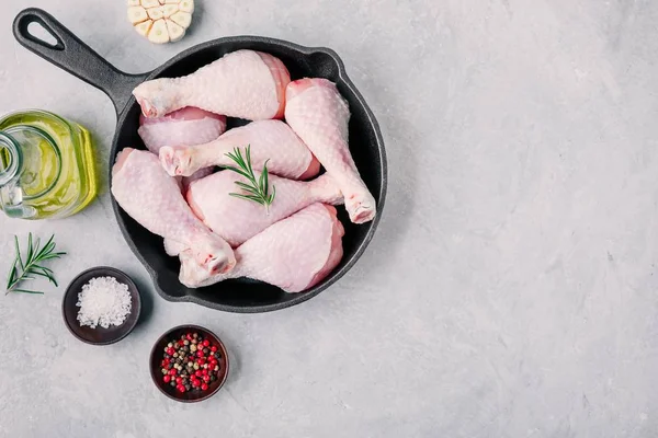 Patas de pollo crudas sin cocer con romero y especias en sartén de hierro fundido . —  Fotos de Stock