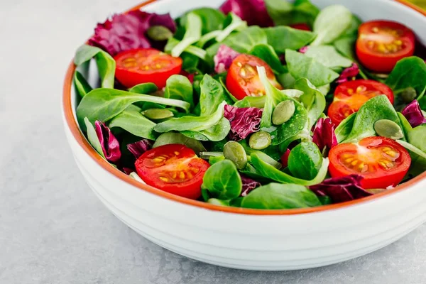 Saladier vert frais avec radicchio, tomates et graines de citrouille . — Photo