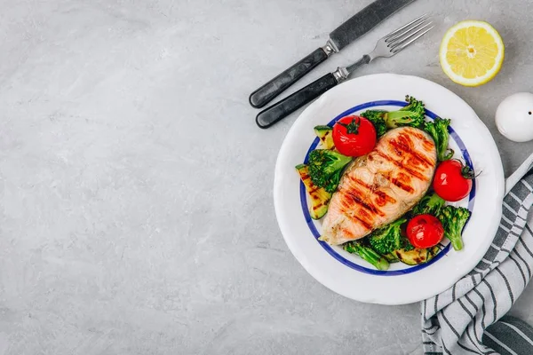 Bife de salmão grelhado e legumes assados. Tomate, brócolis, abobrinha com filé de salmão. Vista superior — Fotografia de Stock