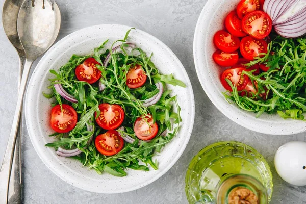Healthy Green Fresh Arugula Salad Bowl with Tomatoes and Red Onions. Top view — Stock Photo, Image