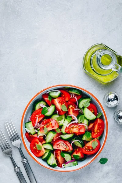 Ensaladera fresca de verano con tomates, pepinos, cebollas rojas, albahaca y aceite de oliva . —  Fotos de Stock