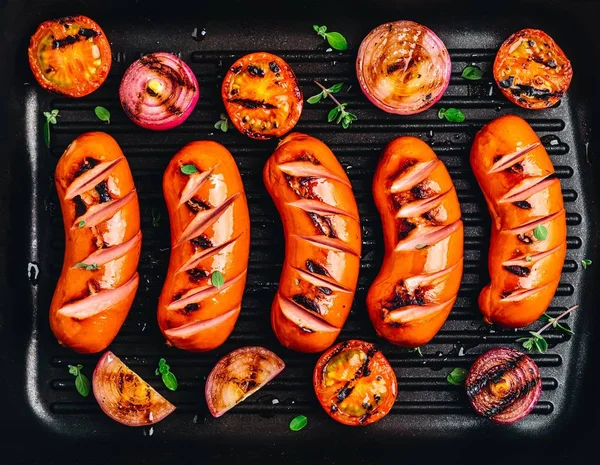 Salsichas grelhadas e legumes em ferro fundido pan closeup . — Fotografia de Stock