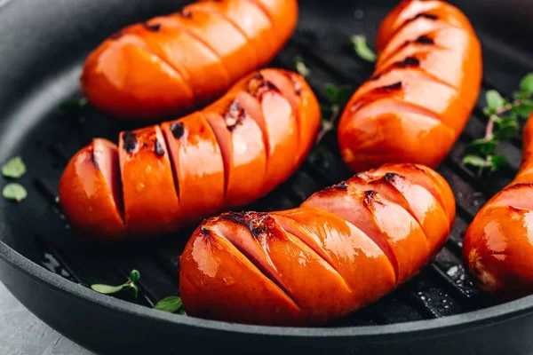 Grilled sausages in cast iron pan. — Stock Photo, Image