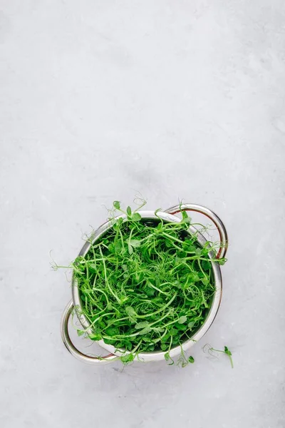 Сырой органический зеленый горошек в коландере, вид сверху — стоковое фото