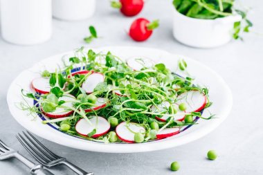 Taze yeşil bezelye turp ile salata vuruyor. 