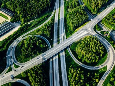 Finlandiya'da yeşil ormanlı otoyol ve üst geçidin havadan görünümü.