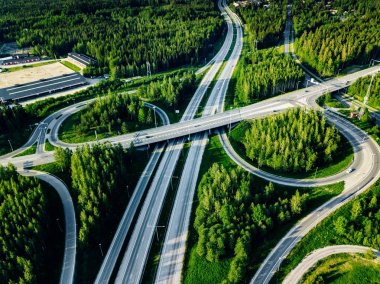 Finlandiya'da yeşil ormanlı otoyol ve üst geçidin havadan görünümü.