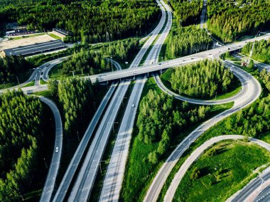 Finlandiya'da yeşil ormanlı otoyol ve üst geçidin havadan görünümü.