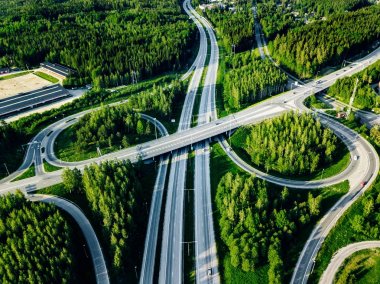 Finlandiya'da yeşil ormanlı otoyol ve üst geçidin havadan görünümü.