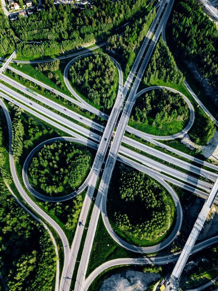 Aerial view of highway and overpass with green woods in Finland.