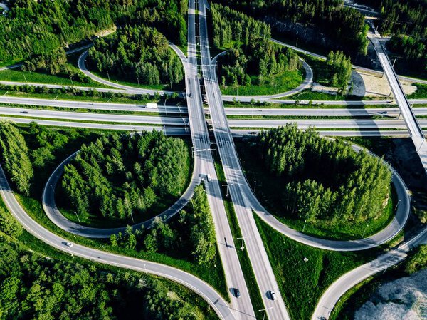 Aerial view of highway and overpass with green woods in Finland.