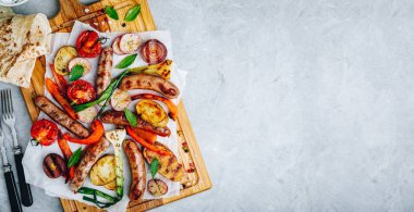 Ahşap tahtada ızgara sebze ve sosis,