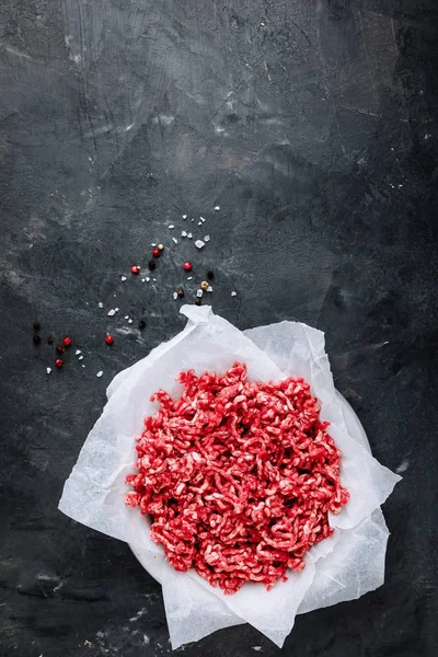 Carne moída crua picada e temperos em fundo escuro — Fotografia de Stock