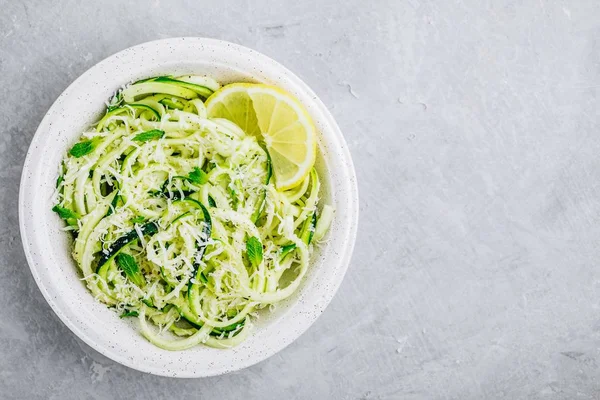 Green vegetarian pasta. Spiralized zucchini noodles with mint, lemon and parmesan cheese — Stock Photo, Image