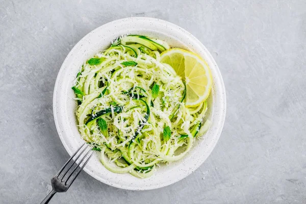 Green vegetarian pasta. Spiralized zucchini noodles with mint, lemon and parmesan cheese — Stock Photo, Image