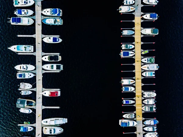 Aerial view of boats, yachts, water bike and wooden sauna in a marina in Finland