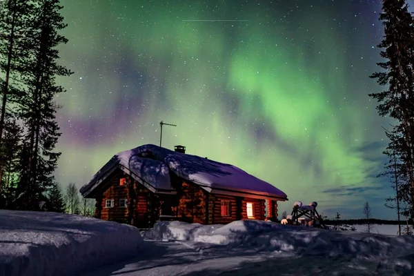 Sarki sarkvidéki északi fények Aurora Borealis aktivitás a faházba télen Finnország, Lapland — Stock Fotó