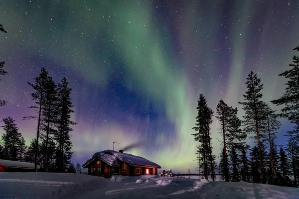 Polar arctic Northern lights Aurora Borealis activity over wooden house in winter Finland, Lapland — Stock Photo, Image