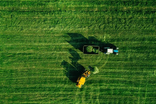 Aerial view of harvest field with tractor moving hay bale — Stock Photo, Image