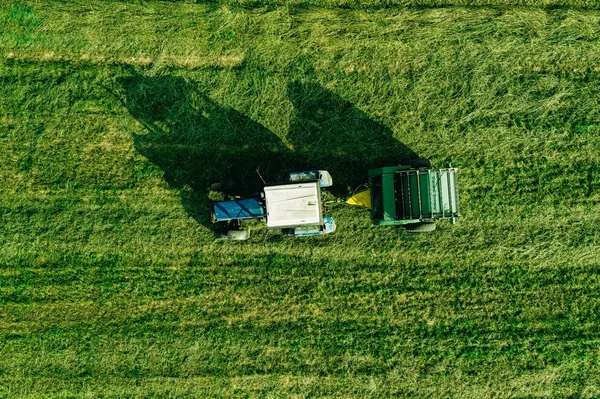 Flygvy över skördefältet med traktor rörlig hö bal — Stockfoto