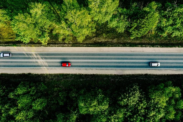 Vista aérea de los coches que conducen a través del bosque en la carretera del país . —  Fotos de Stock