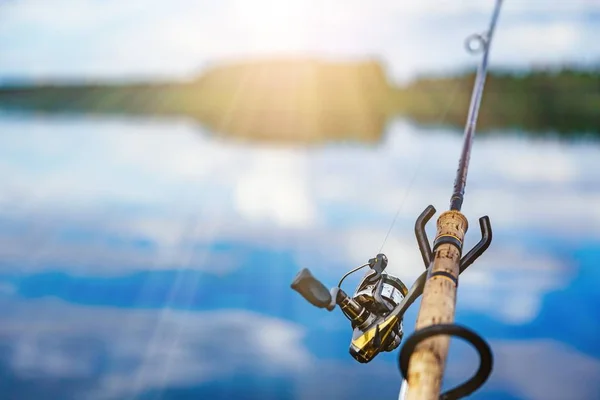 Caña de pescar de cerca con un hermoso amanecer en el lago azul en Finlandia —  Fotos de Stock