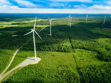 Finlandiya'da yaz ormanında yel değirmenleri havadan görünümü. Temiz ve Yenilenebilir Enerji ile elektrik enerjisi için rüzgar türbinleri 
