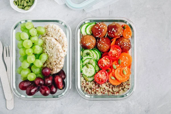 Meal prep lunch box containers with quinoa, meatballs cucumbers, carrots and pumpkin seeds