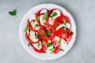 Domates, fesleğen, balzamik sirke ve zeytinyağı ile mozzarella Caprese salatası. 