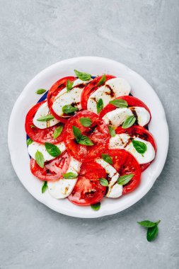 Domates, fesleğen, balzamik sirke ve zeytinyağı ile mozzarella Caprese salatası. 