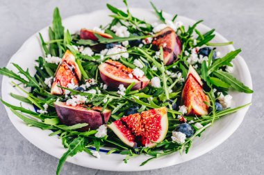 İncir, yaban mersini ve keçi peyniri ile Arugula salatası, balsamik sos sosu