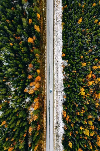 Αεροφωτογραφία του πρώτου φθινοπώρου χιόνι δάσος χρώμα και ένα δρόμο με αυτοκίνητο στη Φινλανδία. — Φωτογραφία Αρχείου