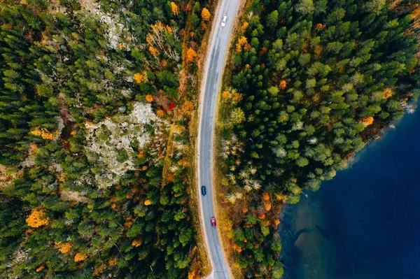 Légi kilátás út és színes őszi erdő kék tavak Finnországban. — Stock Fotó
