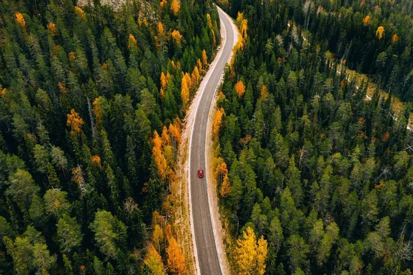 Αεροφωτογραφία του φθινοπώρου δάσος χρώμα στα βουνά και ένα δρόμο με το αυτοκίνητο στη Φινλανδία Λαπωνία. — Φωτογραφία Αρχείου