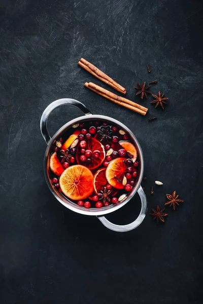 Mulled Wine Hot Drink with Cranberries, oranges, apples and spices on dark concrete background. — Stock Photo, Image