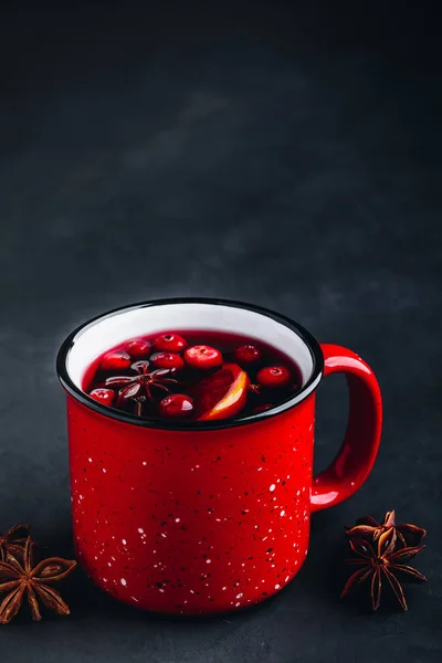 Traditional Christmas Mulled Wine drink with cranberries, orange slices and spices in red mug — Stock Photo, Image