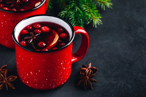 Traditional Christmas Mulled Wine drink with cranberries, orange slices and spices in red mugs — Stock Photo, Image