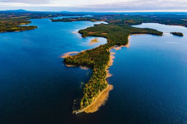 Finlandiya 'da sonbahar manzarası, mavi göller ve güzel sonbahar ormanları.