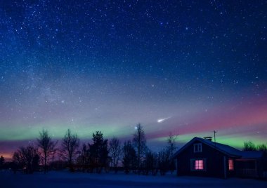 Samanyolu ve arktik kuzey ışıkları ile gece gökyüzüne karşı kır evi kar altında Aurora Borealis