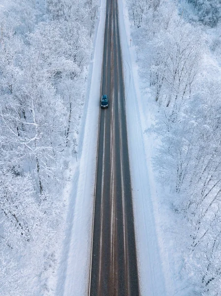 Vista aérea de un camino de invierno con bosque de nieve —  Fotos de Stock
